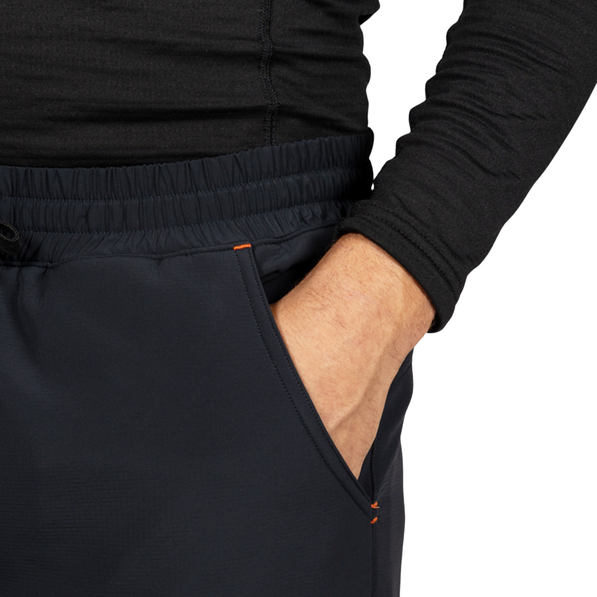 Close-up of a person wearing athletic pants with an elastic waistband and side pocket, with one hand in the pocket. A black long-sleeve top is also visible against a plain white background.