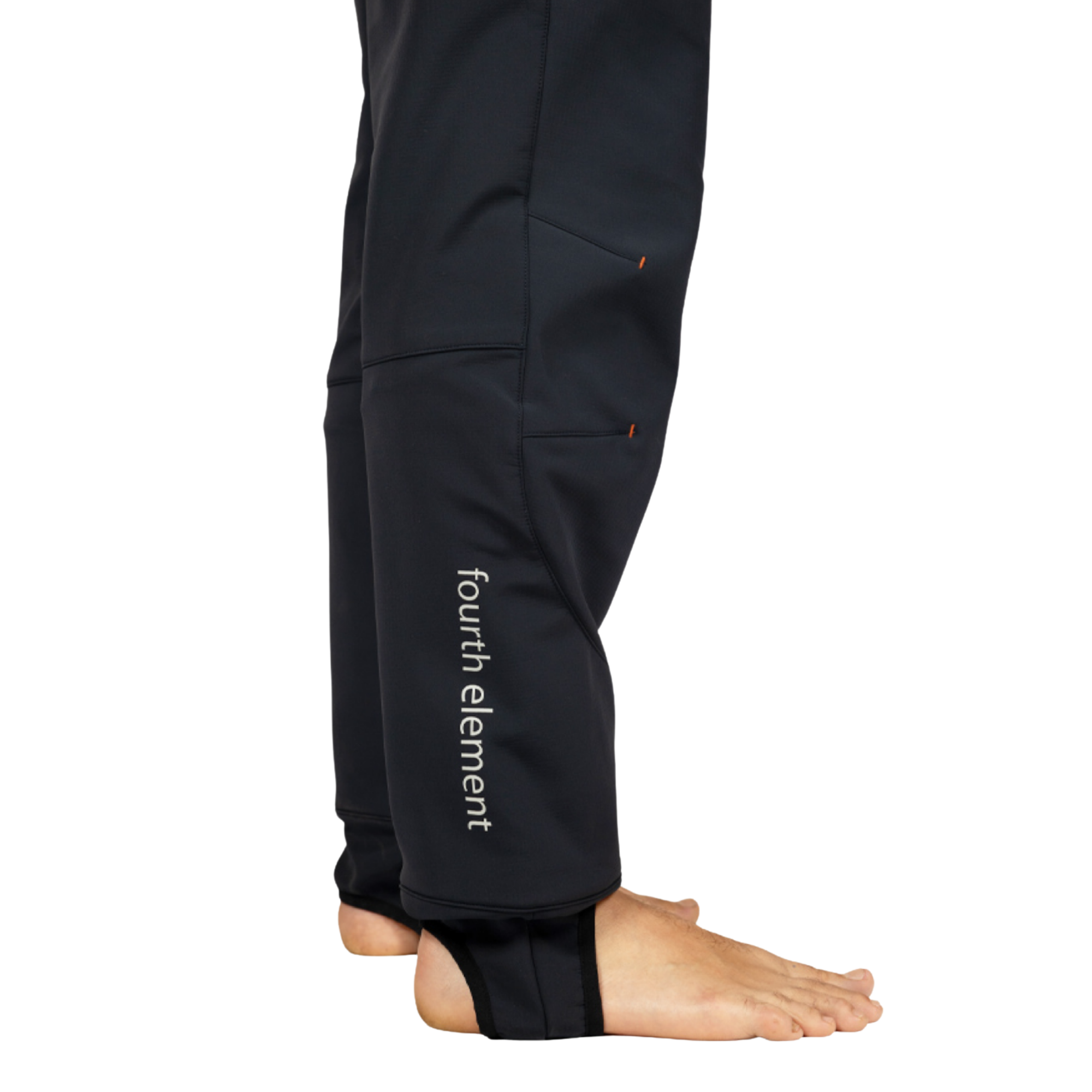 Close-up side view of a person wearing black Fourth Element pants with ankle cuffs, shown barefoot against a white background.