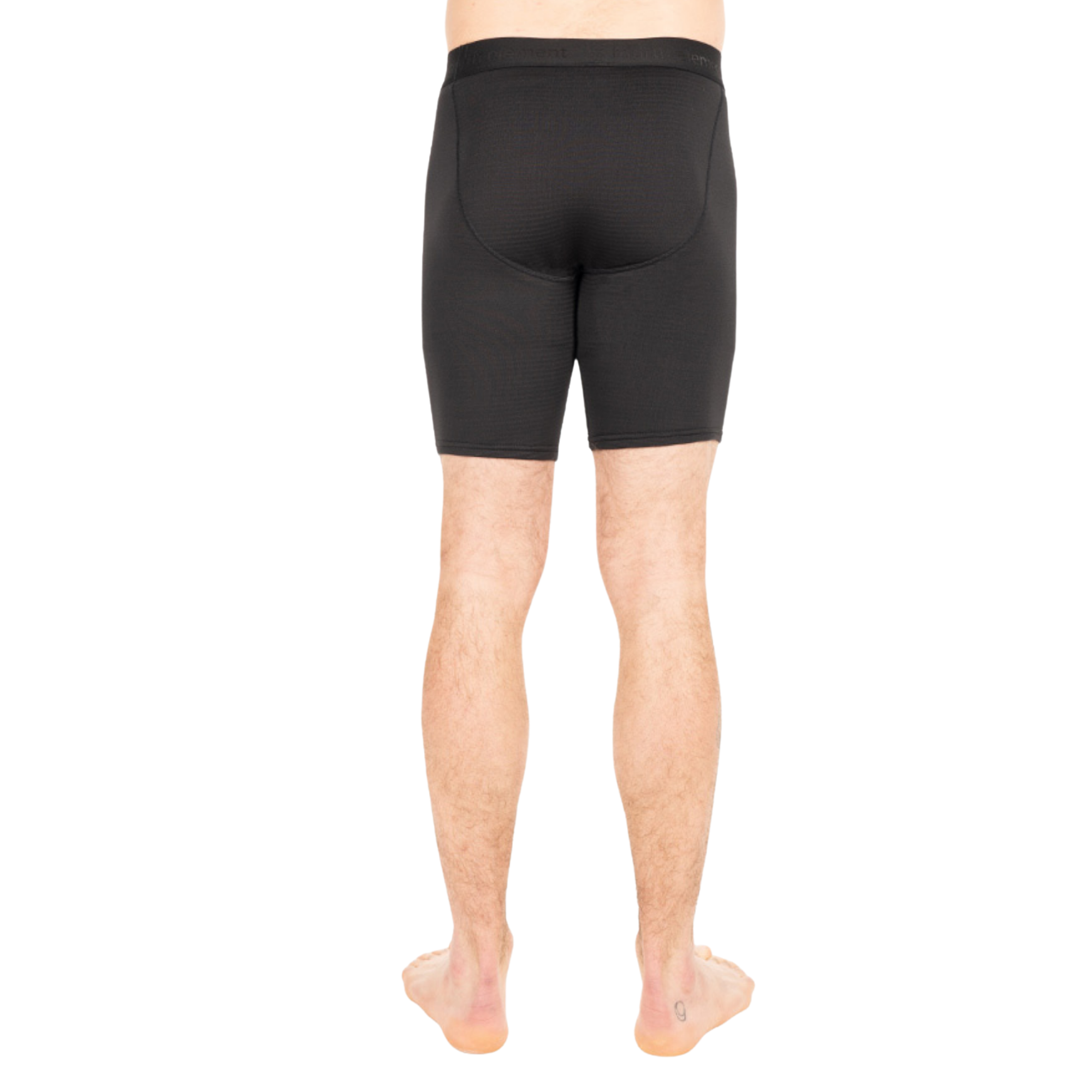 Rear view of a person wearing black compression shorts against a plain white background.