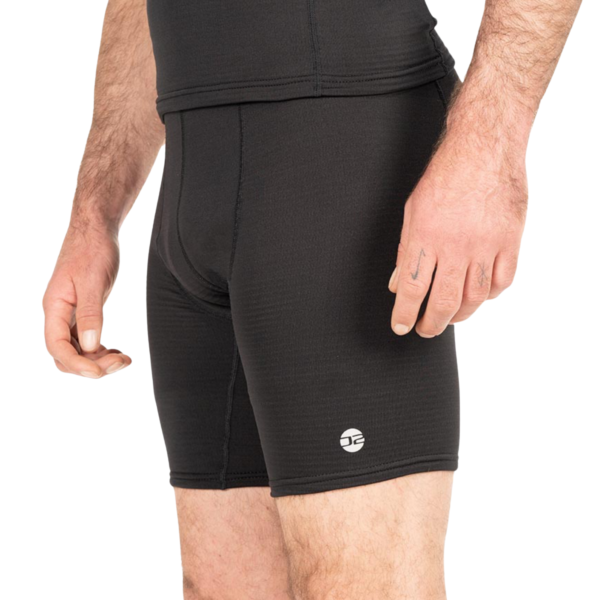 Black athletic compression shorts worn by a model, featuring a small white circular logo on the lower left leg, shot against a plain white background.