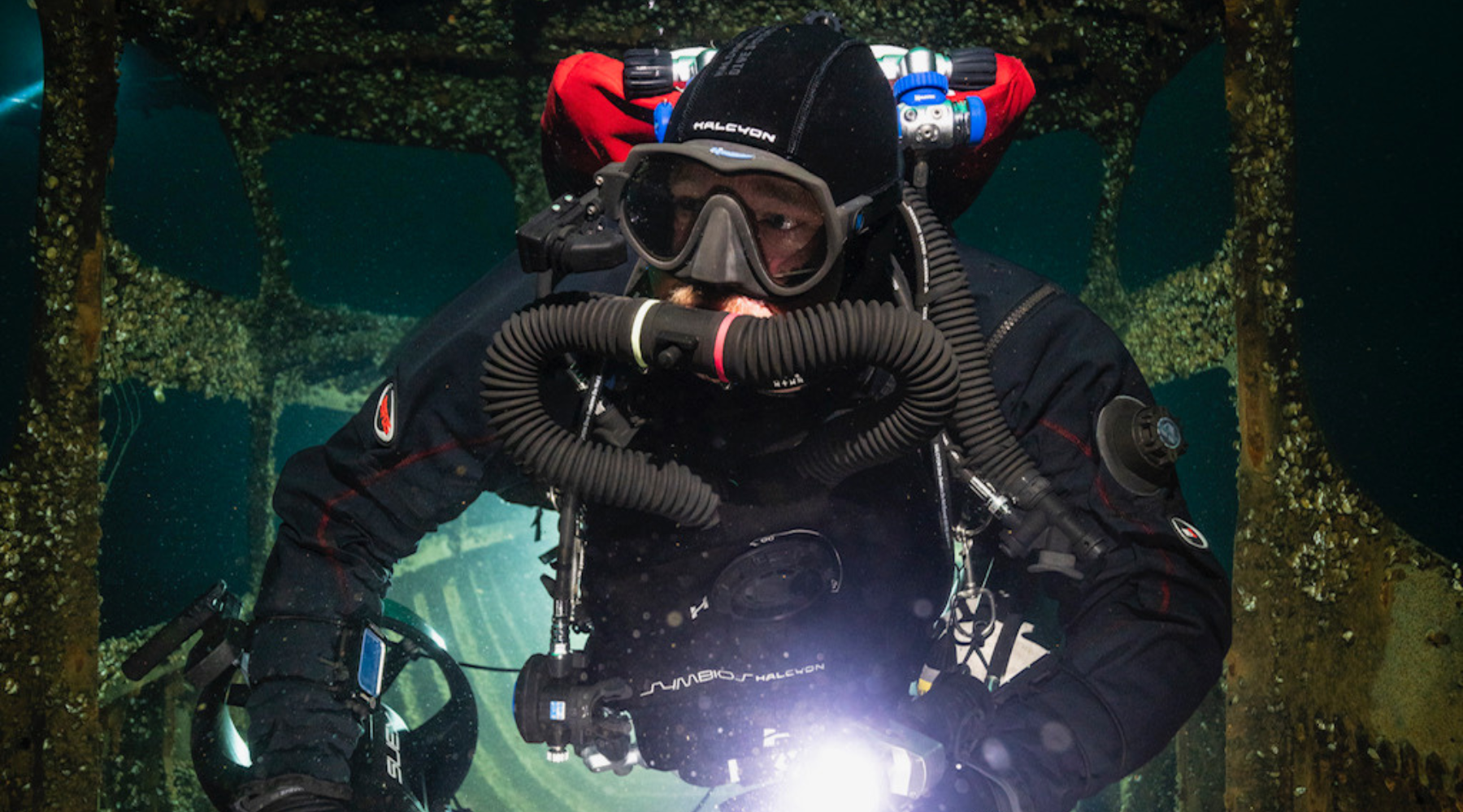 A scuba diver in drysuit underwater with Halcyon chest-mounted Symbios CCR