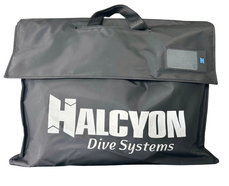 A black Halcyon Dive Systems Traverse Bag, with a top handle, a flap closure featuring large white brand lettering on the front. Ideal for divers.