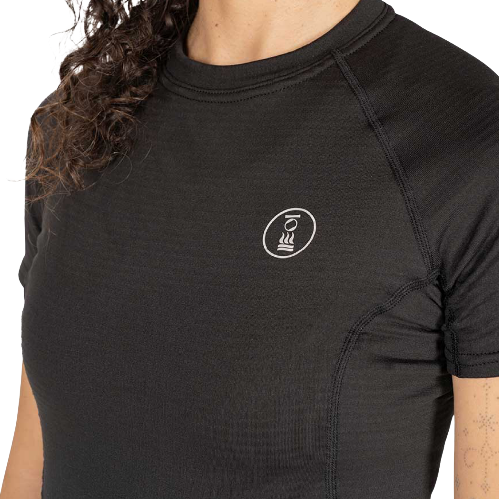 Close-up of a person wearing a black short-sleeve athletic top with a small white circular logo on the left chest, photographed against a plain white background.