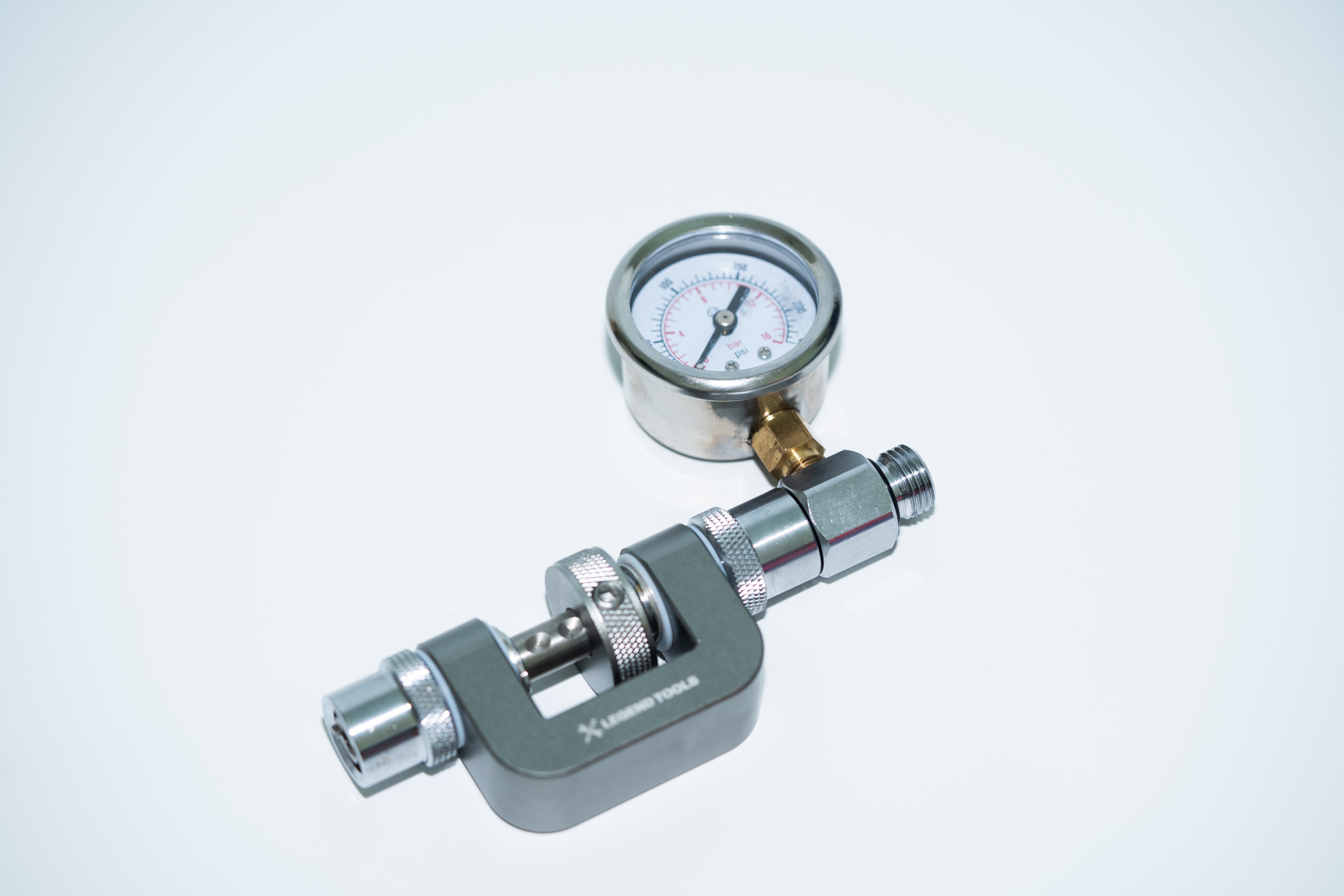 In-line adjusting tool with intermediate pressure gauge